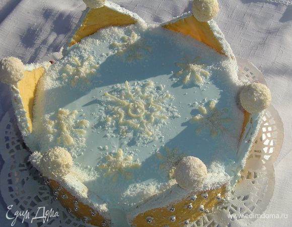 Из белого шоколада готовим снежинки, укладываем их сверху на торт, по окружности посыпаем кокосовой стружкой, а на острие "домиков" помещаем конфеты-рафаэллки, предварительно сделав в них отверстия.