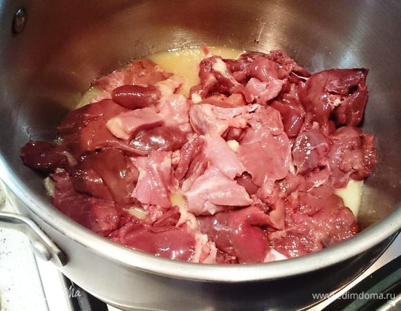 В кастрюле с толстым дном растопить сливочное масло, выложить туда нарезанное небольшими кусочками филе птицы и печень.