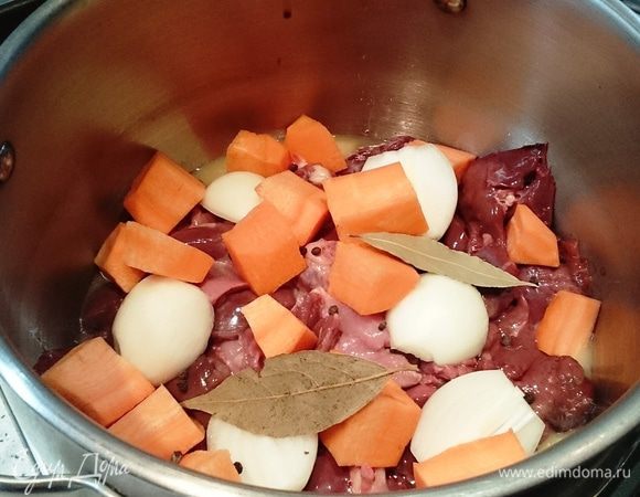 Туда же положить крупно нарезанные морковь и лук, лавровый лист, перец горошком. На сильном огне довести до кипения, убавить огонь до минимума, накрыть крышкой и тушить 30 минут.