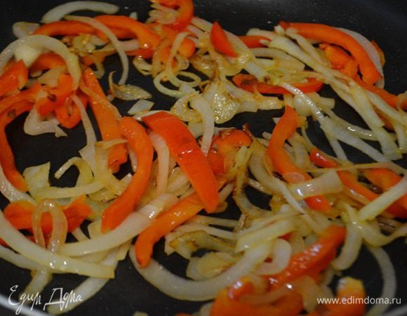 На раскаленной сковороде с оливковым маслом обжарить лук и болгарский перец в течение 7 минут. Добавить рубленый чеснок и жарить еще в течение 1 минуты.