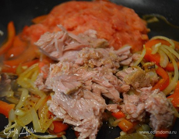 К овощам добавить баночку тунца (масло предварительно слить) и стакан протертых помидор. У меня помидоры замороженные. Я их обдала кипятком, сняла кожу и натерла на мелкой терке. Все хорошо перемешать и тушить в течение 7 минут.