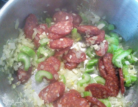 Добавляем чеснок и колбаски, обжариваем в течение двух минут.