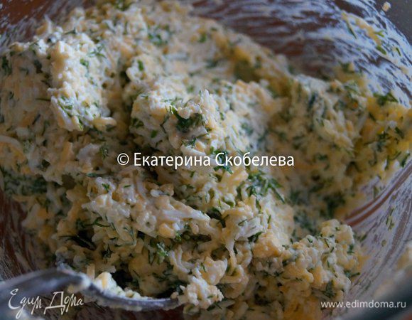 Яйца нужно сварить вкрутую. Чтобы скорлупа не треснула их нужно класть в подсоленную холодную воду. Остудить, очистить и натереть на мелкой терке. Сыр нужно тоже натереть на мелкой терке. Измельчить зелень. Чеснок пропустить через пресс и мелко порубить ножом. Все смешать в одной миске посолить, поперчить и заправить майонезом.