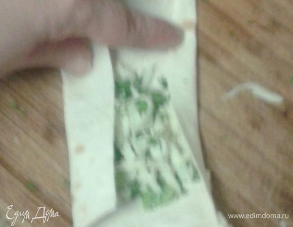 Лаваш нарезать полосками приблизительно 10х25 см. Завернуть в него смесь сыра и зелени.  