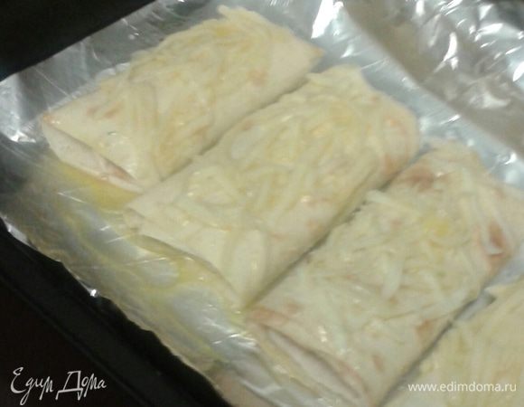 Далее выложить  на противень, предварительно смазанный растительным маслом, сверху посыпать оставшемся тертым сыром. 