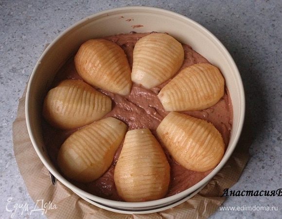 Духовку разогреть до 175 градусов. Дно разъемной формы 26 см выложить бумагой для запекания. Выложить в форму тесто, разровнять. Сверху в виде круга разложить груши.