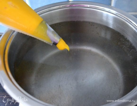 Одновременно в большой кастрюле довести до кипения воду. Посолить. Приготовить также миску с холодной водой и чистое кухонное полотенце. Тесто переложить в кулинарный мешок с гладкой насадкой диаметром около 2-2,5 см. Далее, держа одной рукой кулинарный мешок и осуществляя на него небольшое давление, позволяем тесту выходить из мешка и, держа в другой руке нож, отрезаем им кусочки теста размером 1,5-2 см, позволяя им падать в воду. У нас получаются вот такие заготовки под заварные ньокки.