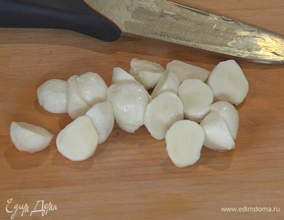 Шарики моцареллы разрезать пополам.