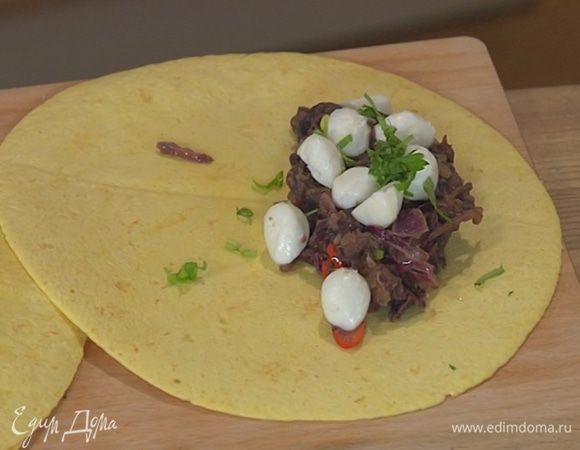 На половину каждой лепешки выложить начинку, сверху разложить моцареллу, посыпать измельченной кинзой, накрыть второй половинкой лепешки и слегка прижать руками. Сбрызнуть лепешки оставшимся оливковым маслом и выложить на противень.