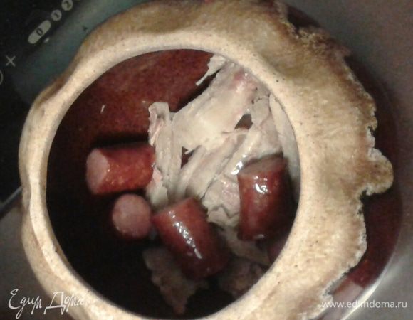 Далее слоями укладываем горшочек.  Первым делом кладем мясо, затем колбаски, 