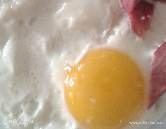 На сковородку налить немного масла (растительного, а лучше оливкового) Выкладываем колбаску, обжариваем с одной стороны, затем переворачиваем и аккуратно выливаем яйцо внутрь. Солим, жарим до готовности. 