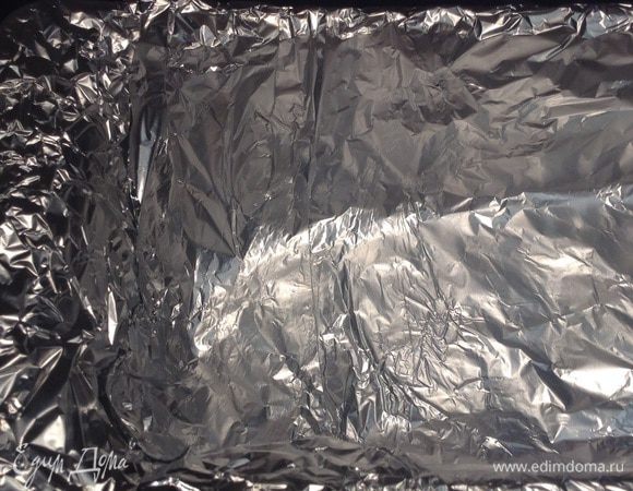 Прямоугольную форму застелить фольгой и пищевой пленкой. 