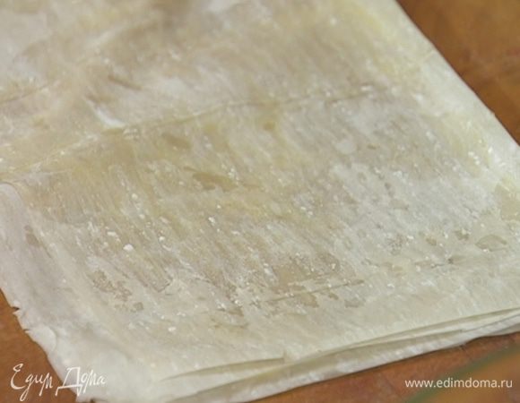 Листы фило смазать растопленным маслом, сложить пополам и снова смазать маслом, затем еще раз сложить пополам и смазать маслом.