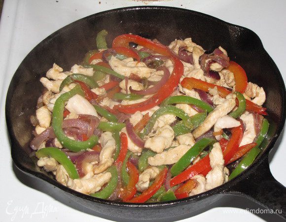 Добавить нарезанное тонкими полосками куриное филе и продолжать жарить, помешивая, еще 7 минут. Затем добавить нарезанные соломкой маринованные огурцы и белое вино. Еще немного готовить до выпаривания вина. Можно обойтись и без вина, кстати, в рецепте его не было. Это я уже добавила от себя, т.к. в мексиканском ресторане ела именно такой фахитас и мне понравилось.