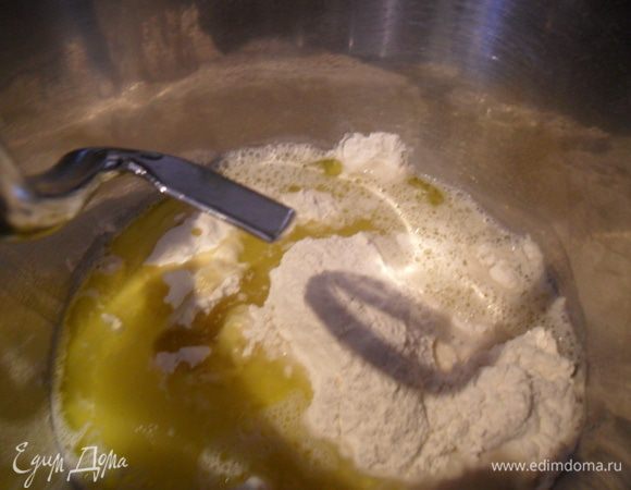 В чашу комбайна или в миску всыпать муку, дрожжи, соль (2 чайные ложки чуть без горки), влить оливковое масло, теплую воду и все хорошенько перемешать.