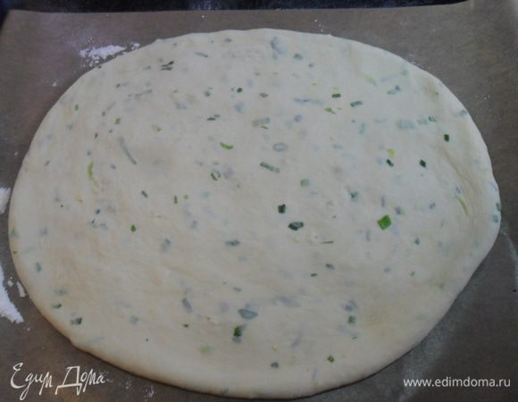 Противень застелить пергаментной бумагой, хорошо присыпать мукой и раскатать овальную лепешку, я это делаю руками, просто растягиваю прижимаю пальцами.