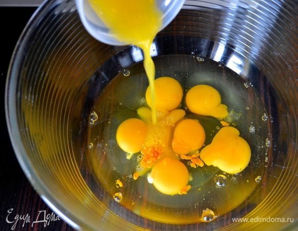 Два апельсина вымыть и натереть цедру. Выдавить 50 мл сока. В огнеупорную форму разбить яйца, добавить цедру апельсинов и апельсиновый сок. 