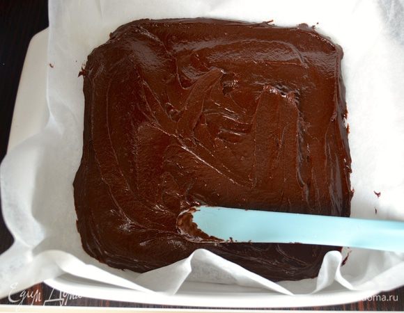 Квадратную форму (25 см х 25 см) выложить бумагой для выпечки. Шоколадную массу распределить по всей форме, помогая себе лопаткой или ложкой (тесто достаточно густое). 