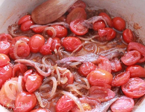 Для соуса разогрейте в сковороде 2 столовые ложки масла и обжарьте нарезанный кружочками лук. Добавьте помидоры и закройте крышкой, тушите 15 минут. Затем добавьте анчоусы и уберите с плиты.

Разогрейте духовку до 220 градусов.