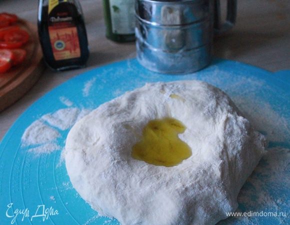 Выложите тесто на стол, полейте оставшимся маслом и вымешивайте его 10 минут.