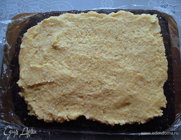 Выложить крем на охлажденный корж, равномерно распределить его и свернуть рулет. Крема получается довольно много, поэтому скрутить довольно проблематично. Я просто соединила две противоположные стороны, плотно прижав их. Они немного заступили друг на друга. Плотно завернуть рулет пленкой со всех сторон. За всю эту "операцию" большое спасибо моей маме, она меня очень выручила! :) 