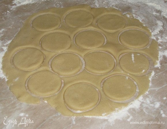 Разделить тесто на две части. Первую раскатать в круг и вырезать рюмкой кружки, толщина кружков примерно 0,5 см.