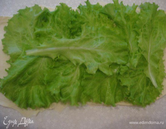 На тесто выложить внахлест листья салата.