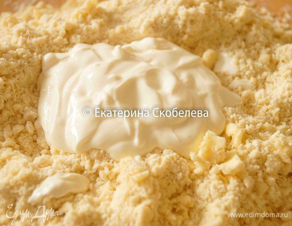 К крошке добавить всю сметану и аккуратно замесить тесто. Оно получается очень эластичным и мягким. Скатать тесто в шар, завернуть в пищевую пленку и убрать в холодильник на час.