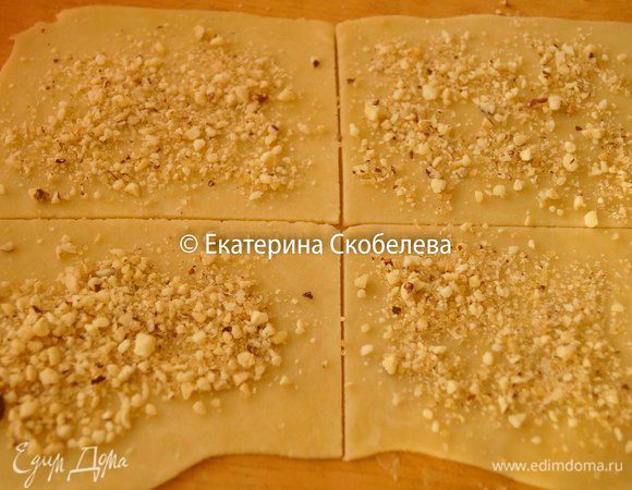 Готовое тесто достать из холодильника и разделить на 4 части. Взять одну часть раскатать тонко и нарезать на квадратики. На каждый квадратик положить начинку, распределить ее по всей поверхности теста.