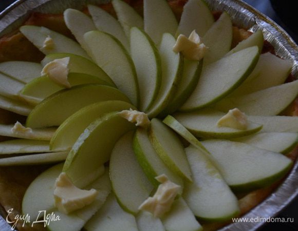 Достать пирог, удалить бумагу с бобовыми и уложить яблоки, сверху на яблоки кладем кусочки сливочного масла. Выпекать еще 20 минут.

Растопить 100г сахара в кастрюле на небольшом огне, добавить яблочный сок и помешивая, варить до консистенции карамели. Достать пирог, полить его карамелью и снова поставить в духовку на 8 минут.