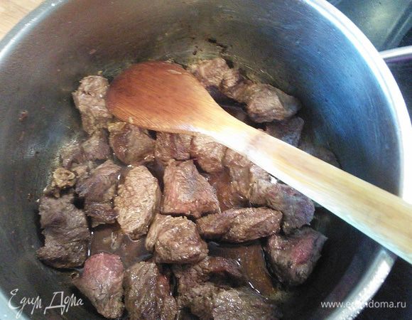 В кастрюле разогреть оливковое масло, обжарить мясо после мытья и нарезки на порционные кусочки со всех сторон до золотистого цвета. 