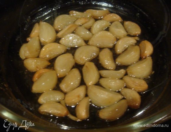 Пока тесто подходит, печем чеснок. Очистить чеснок от кожи. Смешать оливковое масло с 1 ст.л. сахара, добавить чеснок и запечь в предварительно разогретой духовке 20 минут.