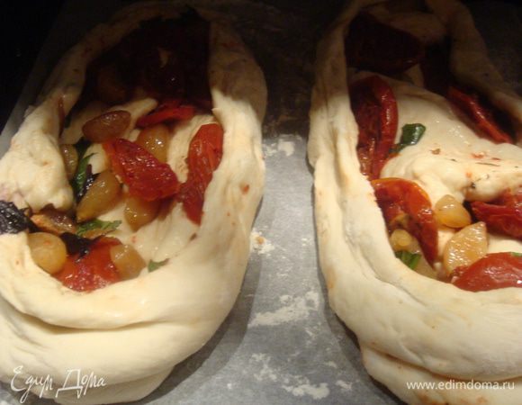 Противень застелить пекарской бумагой. Выложить хлеб на противень, защипанным швом вниз. Верхний слой теста красиво раскрыть.