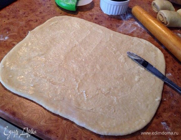 Разделить на две части и раскатать в пласт толщиной 1-1.5 см. 
Размягченное сливочное масло смешать с сахаром и намазать им пласт.