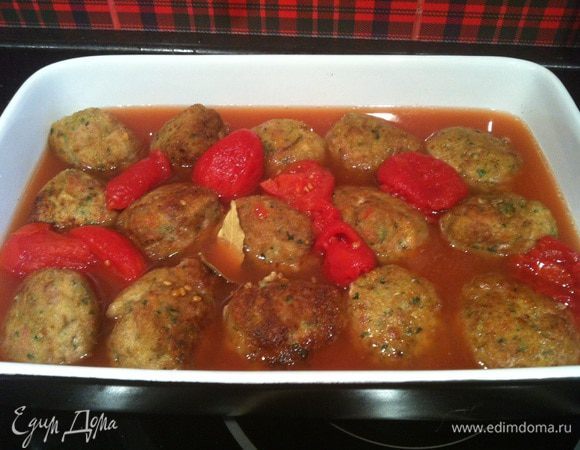 Переложите фрикадельки в форму для запекания, добавьте консервированные томаты, оставшееся оливковое масло, лавровые листья и щепотку соли. Запекайте в предварительно нагретой до 190 градусов духовке 30 минут. Каждые 10 минут поливайте фрикадельки томатным соусом.