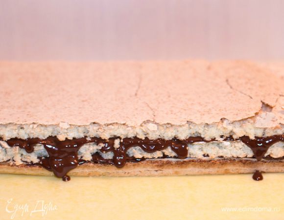 Кокосовый корж разрезать на 3 части. Каждый корж смазать ганашем. Верхний корж и боковые поверхности торта так же покрыть ганашем.