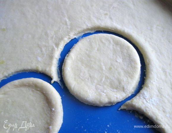 Раскатать тесто на присыпанной мукой поверхности. Чашкой вырезать кружочки, диаметром 8 см.