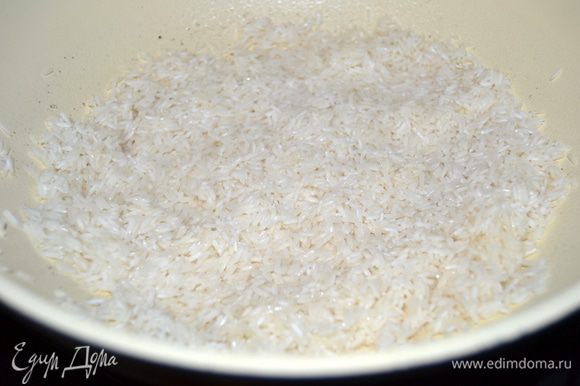 В глубокой сковороде с небольшим количеством масла поджарить рис. До прозрачности.