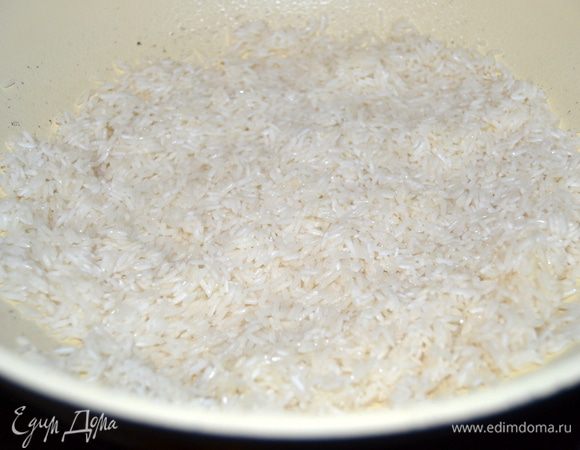 В глубокой сковороде с небольшим количеством масла поджарить рис. До прозрачности.
