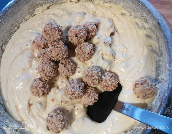 Очень аккуратно вмешать в тесто две пачки конфет "Джотто" или любых других фундучных конфет. Всего нам понадобится 3 пачки конфет, каждая по 38 г. Разогреть духовку до 175°. 