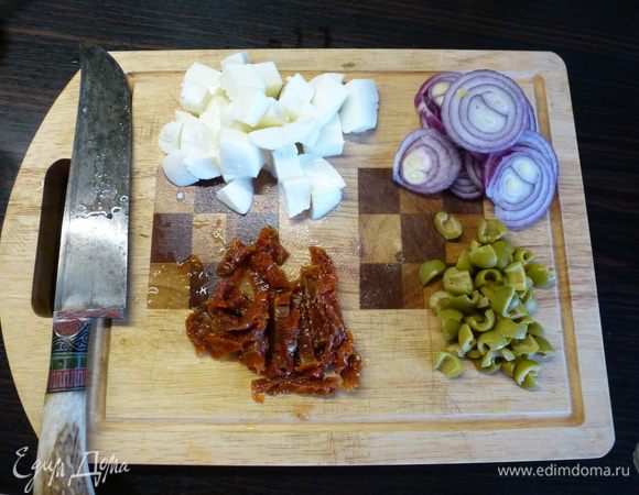 Моцареллу нарезаем кубиком, вяленые помидоры - полосками, оливки - четвертинками, лук - кольцами.