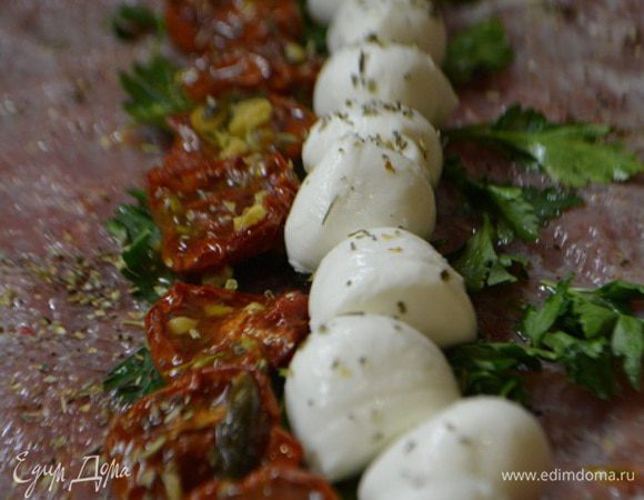 Мясо сбрызнуть соком лимона, посолить и поперчить по вкусу. Уложить по середине листья базилика (в моем случае петрушка), на него ряд вяленых томатов и рядом кружочки моцареллы. Посыпать все итальянскими травами.