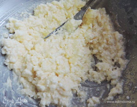 Творог соединить с сахаром. Добавить совсем немножко ванилина или пакетик ванильного сахара, маленькое яйцо и растереть вилкой до однородности.
