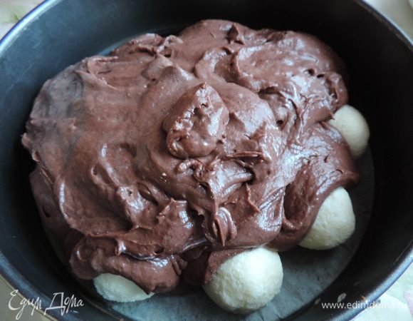 Дно формы диаметром 22-23 см застелить бумагой, бортики смазать маргарином. На дно выложить подмороженные шарики, вылить сверху тесто. Если даже шарики "выглядывают" из теста - не переживайте. Пирог во время выпечки поднимется и шарики спрячутся.
Выпекать пирог в разогретой до 180 градусов духовке 40-45 минут. Его готовность можно проверить деревянной шпажкой, она должна быть сухой.