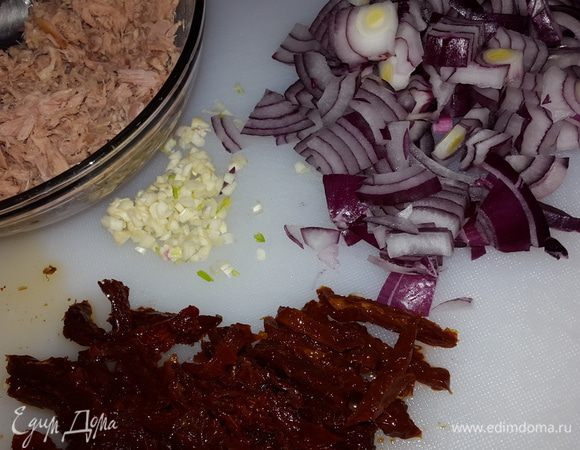 Лук нарезать на четверть кольца, томаты - соломкой, чеснок мелко нарубить. С тунца слить жидкость и размять вилкой.