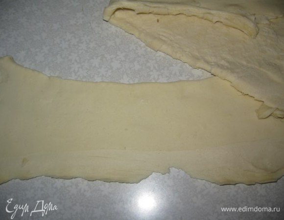 Тесто разморозить при комнатной температуре. Растянуть тесто руками в разные стороны, но не раскатывать. Разрезать на узкие полоски.