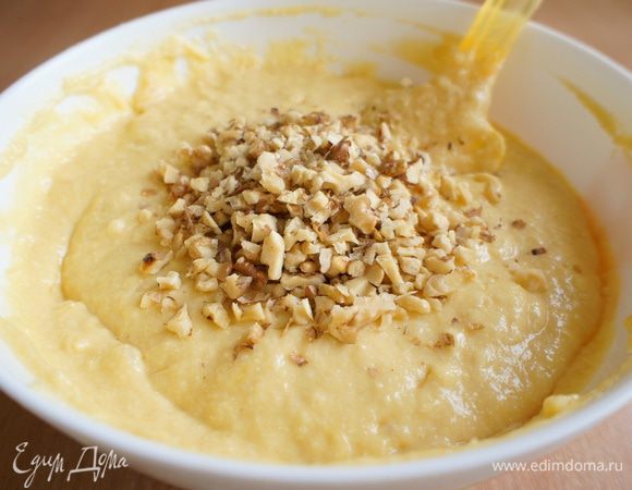 В тесто добавить рубленные грецкие орехи, при этом немного отложить для посыпки сверху. Перемешать.