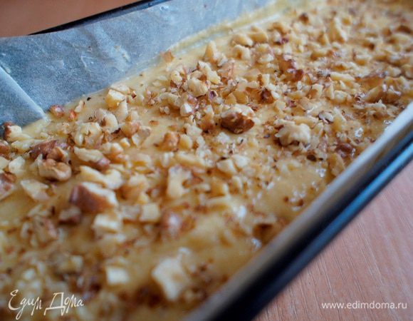 Включить духовку до 190С и разогреть в течение 10 минут. 
Между тем, в форму выложить бумагу для выпечки, смазать сливочным маслом и присыпать мукой.
Тесто выложить в форму. Посыпать оставленными измельченными  грецкими орехами и выпекать 35-40 минут (ориентируйтесь по своей духовке). Готовность проверить деревянной шпажкой.
