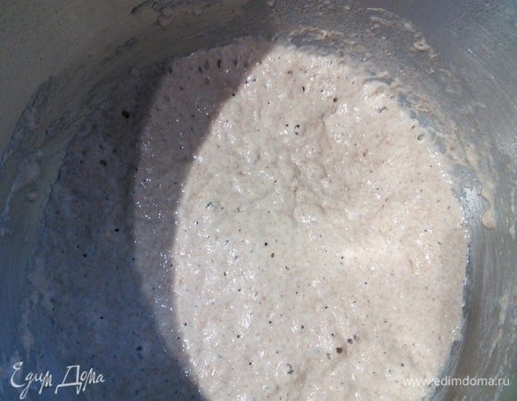 Ставим опару: для этого нужно смешать два вида пшеничной муки с дрожжами и тёплой водой в кашицу. Я взяла для этой цели сразу чашу комбайна. Накрыть плёнкой и оставить на 4—12 часов при комнатной температуре вызревать. Я оставила на ночь, для меня это очень удобно. Так выглядит опара утром. 