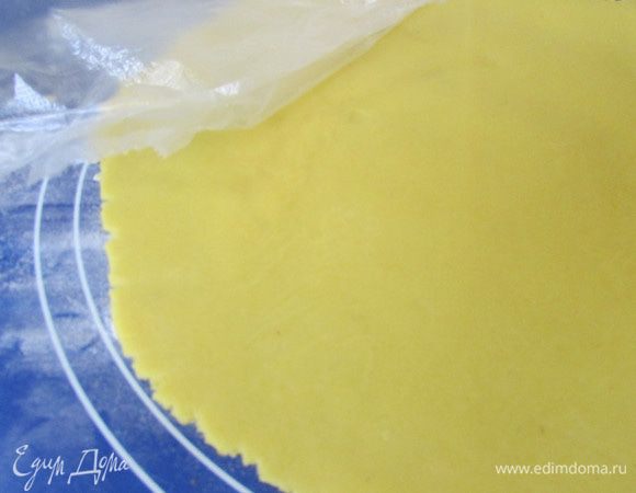 Достать тесто из холодильника, дать ему полежать 20 минут при комнатной температуре. Потом осторожно раскатать круг, толщиной не более 0,4-0,5 см, если нужно, присыпать мукой.